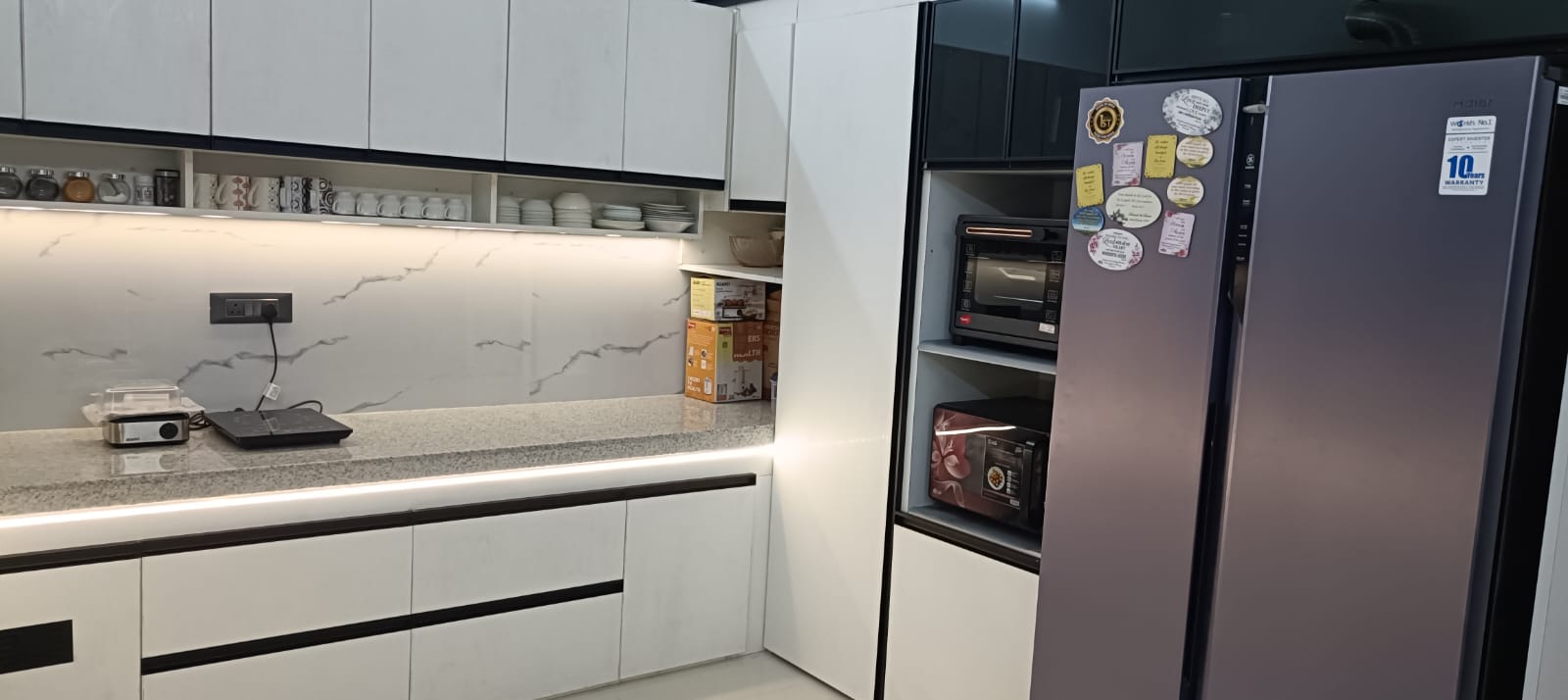 Completed kitchen appliance wall with full-height storage and open shelving
