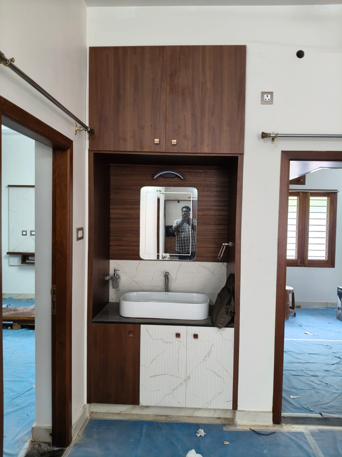 Built-in wash unit with mirror, basin, overhead cabinet, and mixed-finish storage