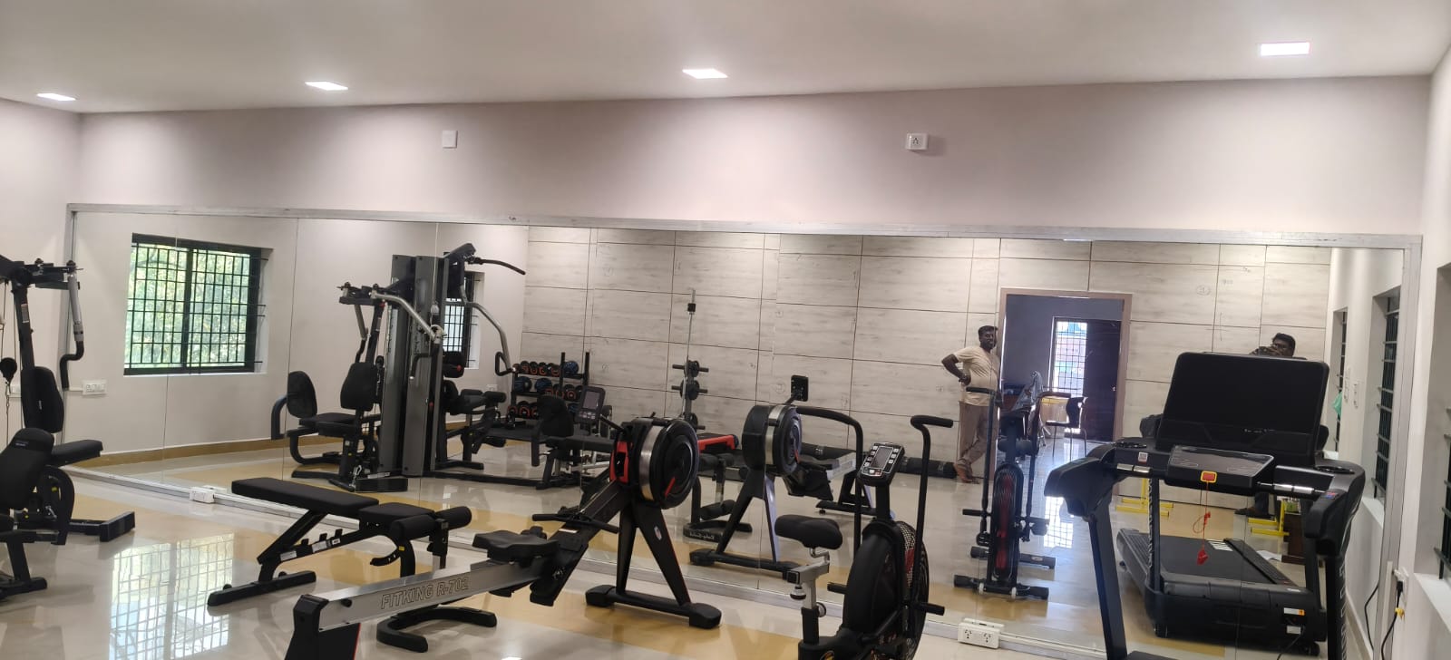 Finished gym mirror wall with cardio and strength equipment