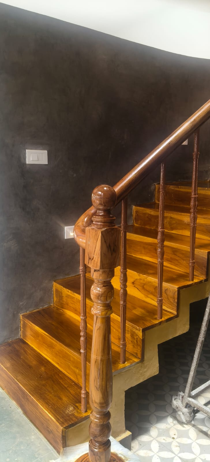 Turned timber newel post, balusters, and handrail at the lower stair flight