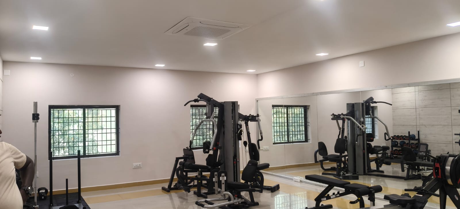 Completed gym renovation with training equipment, mirrors, and recessed ceiling lights