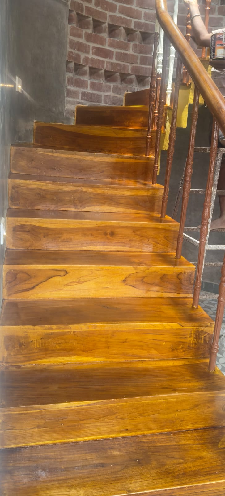 Polished timber steps rising beside the exposed brick wall