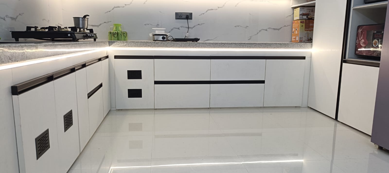 Lower kitchen cabinets with integrated ventilation details and continuous lighting