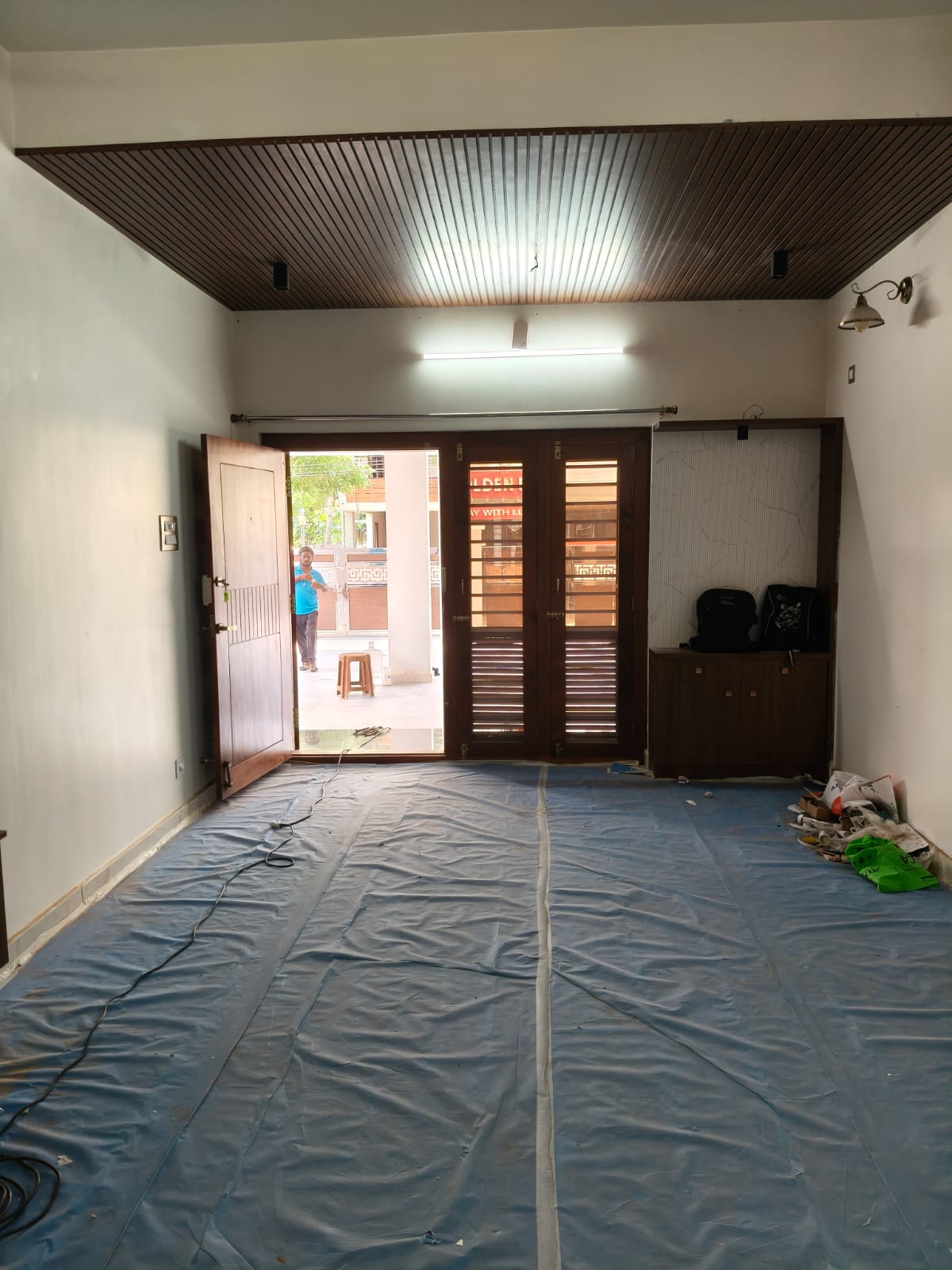 Living room with timber slatted ceiling and fitted entrance storage during final finishing