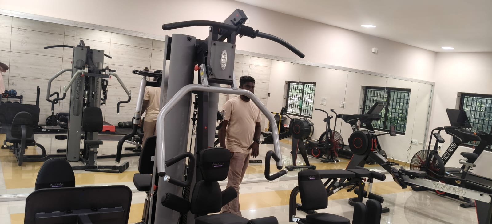 Completed gym equipment area reflected across a full-height mirror wall